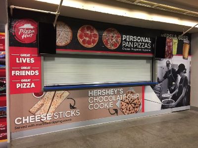 Concession stand branded with Pizza Hut pizza and cheese sticks and Hershey's chocolate chip cookies